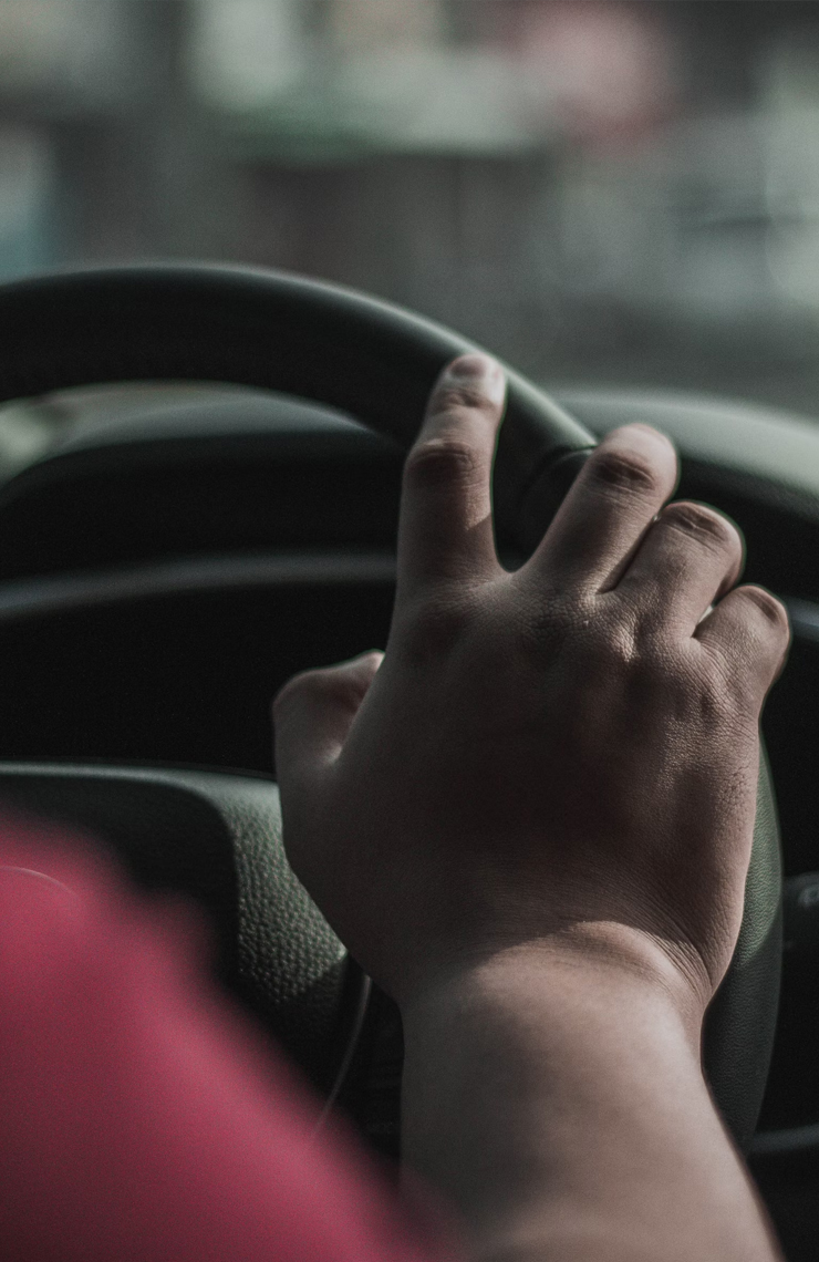 Driver with traffic violations whose hand is on the steering wheel.